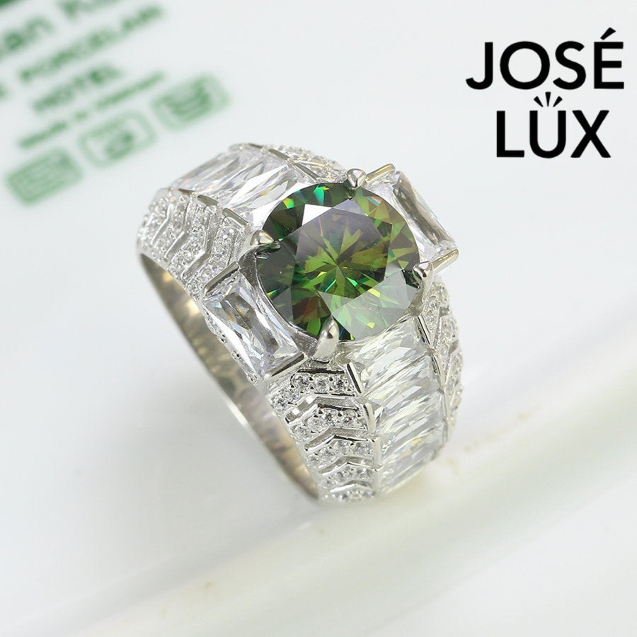 Bold sterling silver men's ring featuring a stunning 4-carat round green moissanite centerpiece surrounded by brilliant baguette-cut accents. Classic design with exceptional sparkle and durability for everyday wear.