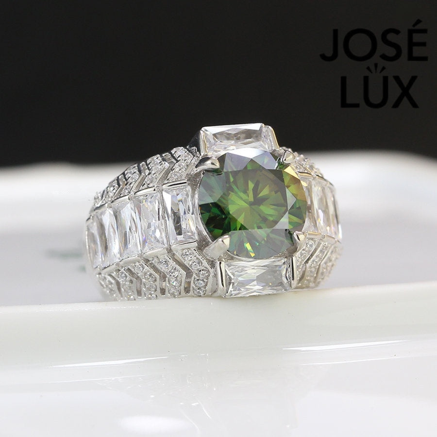Bold sterling silver men's ring featuring a stunning 4-carat round green moissanite centerpiece surrounded by brilliant baguette-cut accents. Classic design with exceptional sparkle and durability for everyday wear.
