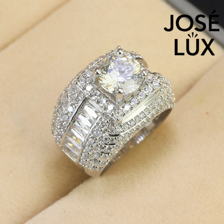 Men's Sterling Silver Moissanite Ring 2CT with Layered Halo Design featuring a round center stone and baguette side stones on a velvet display.