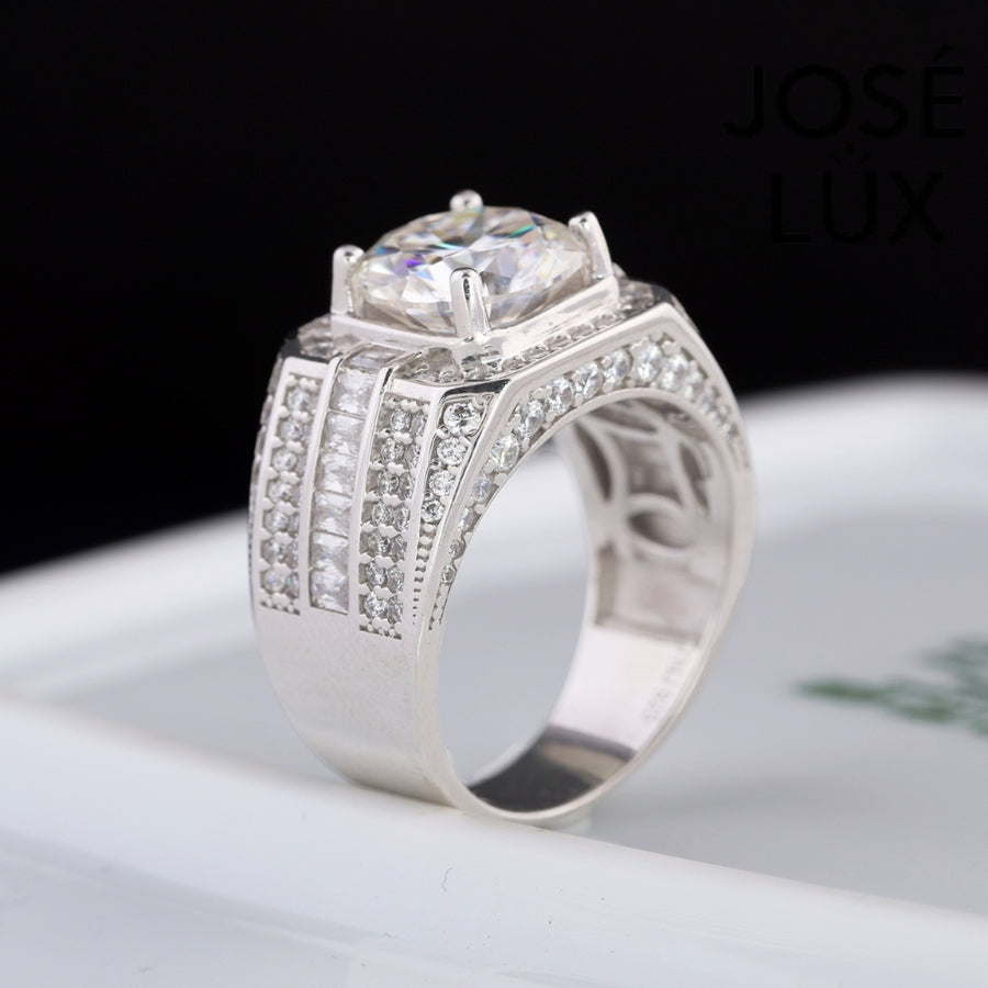 Striking men's ring in sterling silver showcases a brilliant 4-carat round moissanite within an octagonal double halo. Wide band features tiered baguette channels and pavé rows for exceptional sparkle and dimensional design.