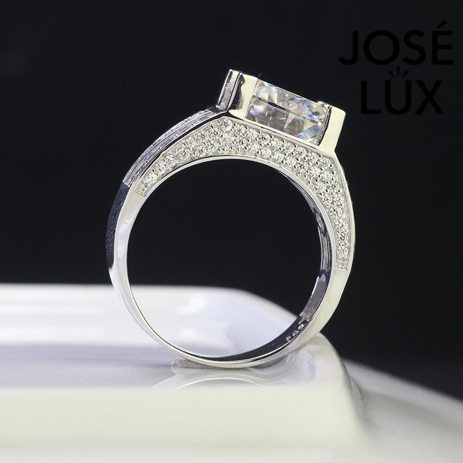 Classic men's ring in sterling silver showcases a brilliant 4-carat round moissanite in four-prong setting. Wide triple-row band features vertical baguette channels bordered by pavé stones for timeless sophistication.