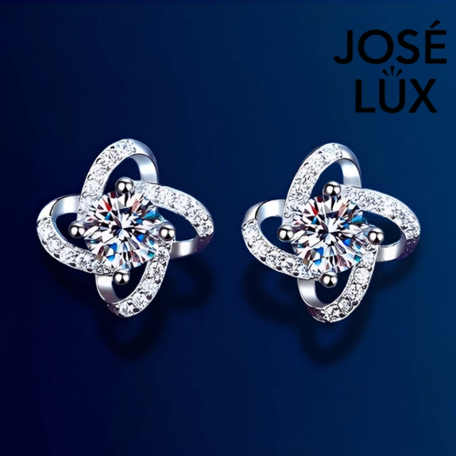 Sparkling flower-shaped moissanite earrings with halo setting in sterling silver. Brilliant fire and scintillation make these studs perfect for elegant everyday wear.