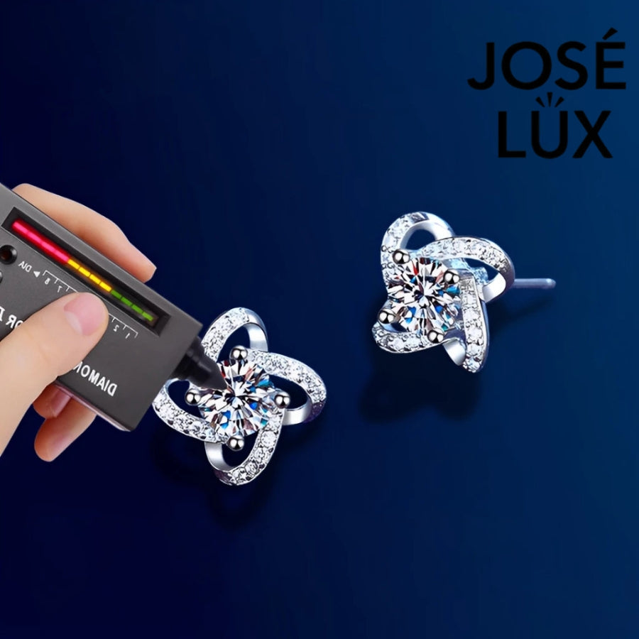Sparkling flower-shaped moissanite earrings with halo setting in sterling silver. Brilliant fire and scintillation make these studs perfect for elegant everyday wear.