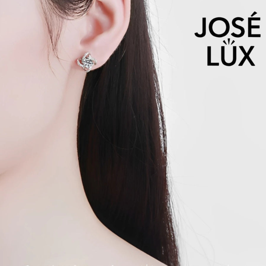 Sparkling flower-shaped moissanite earrings with halo setting in sterling silver. Brilliant fire and scintillation make these studs perfect for elegant everyday wear.
