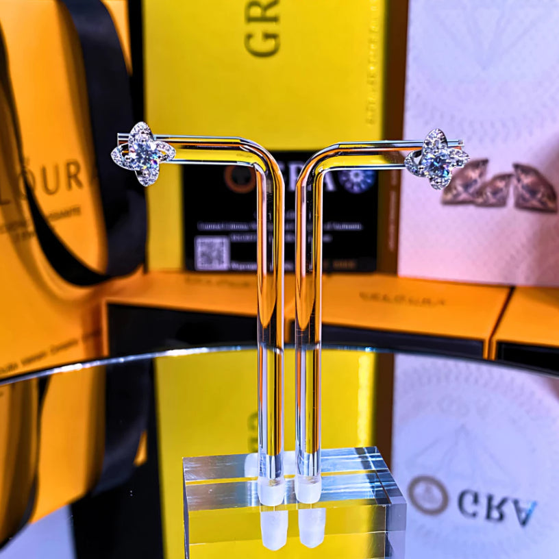 Sparkling flower-shaped moissanite earrings with halo setting in sterling silver. Brilliant fire and scintillation make these studs perfect for elegant everyday wear.