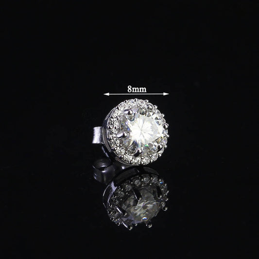 Sterling silver halo studs with 0.8ct round moissanite. Classic design features a brilliant center stone surrounded by smaller accents with secure push-back posts for everyday elegance