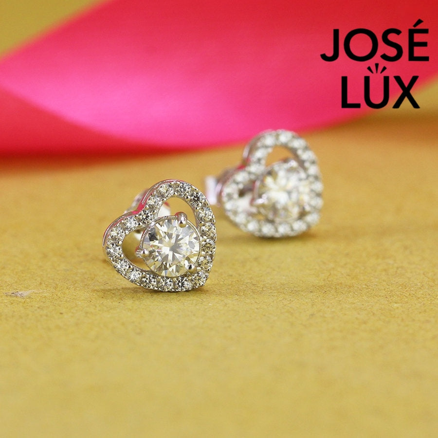 Romantic heart-shaped moissanite with sparkling halo setting in sterling silver. Sweet love-inspired design delivers brilliant fire and scintillation for charming everyday elegance.