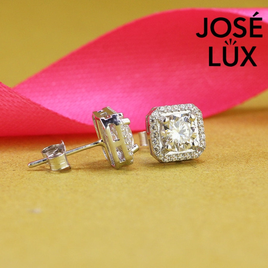 Romantic heart-shaped moissanite with sparkling halo setting in sterling silver. Sweet love-inspired design delivers brilliant fire and scintillation for charming everyday elegance.