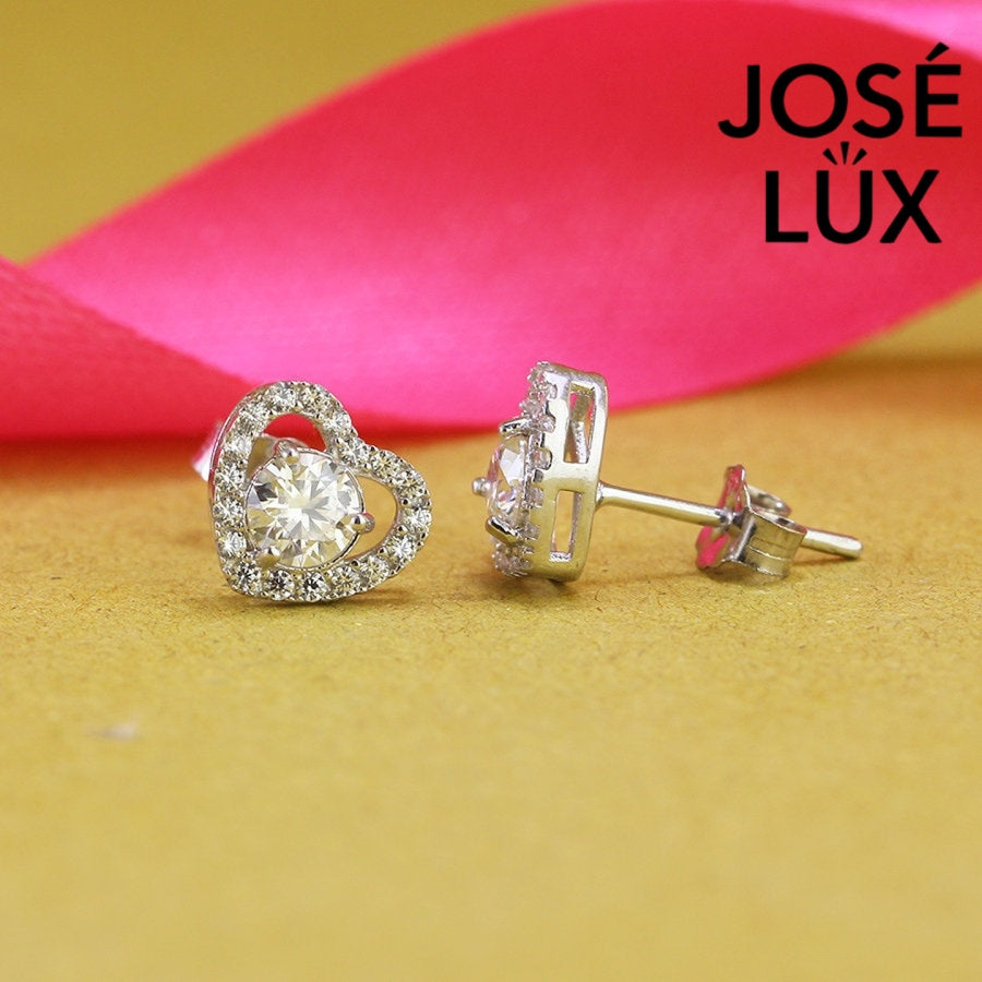 Romantic heart-shaped moissanite with sparkling halo setting in sterling silver. Sweet love-inspired design delivers brilliant fire and scintillation for charming everyday elegance.