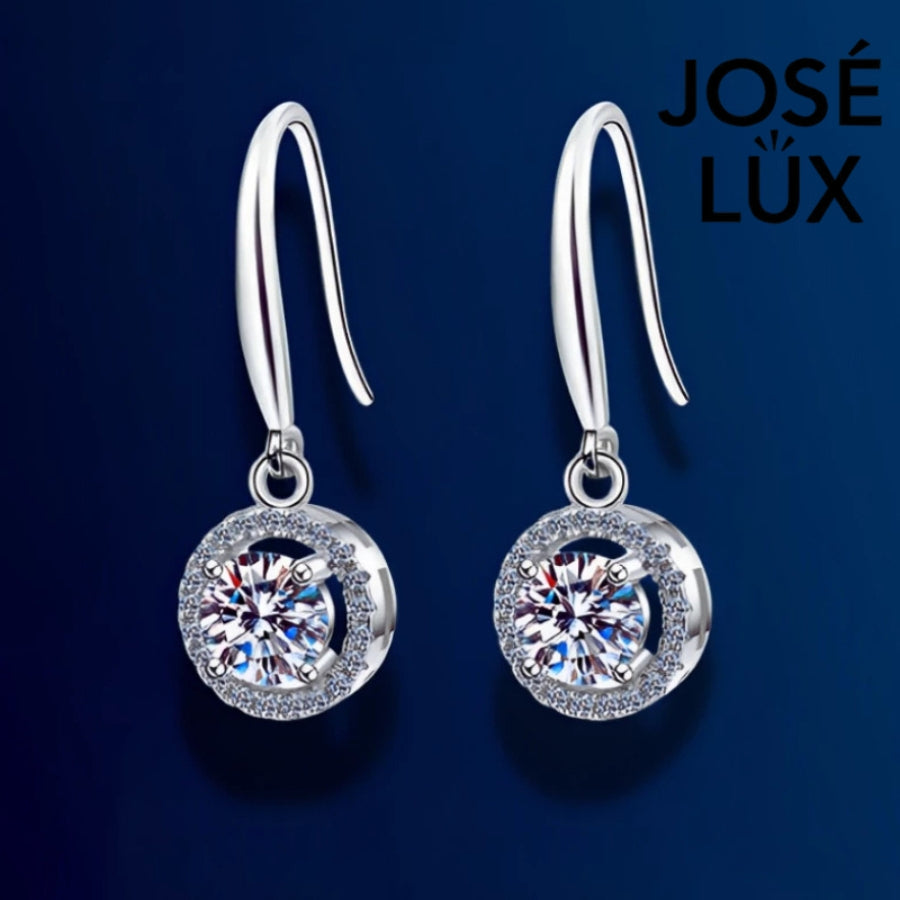Elegant round moissanite with sparkling halo setting in sterling silver. Graceful dangle design adds beautiful movement and brilliant fire for sophisticated everyday wear.