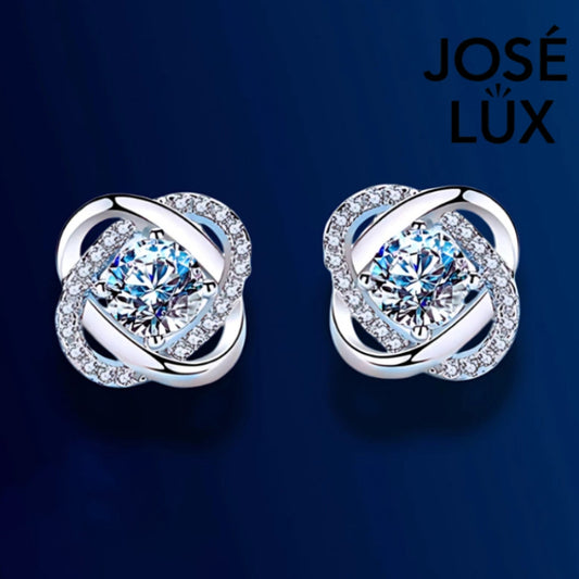 Elegant twisted halo design featuring brilliant moissanite stones in sterling silver. Modern sculptural styling adds sophisticated sparkle to any outfit with exceptional fire.