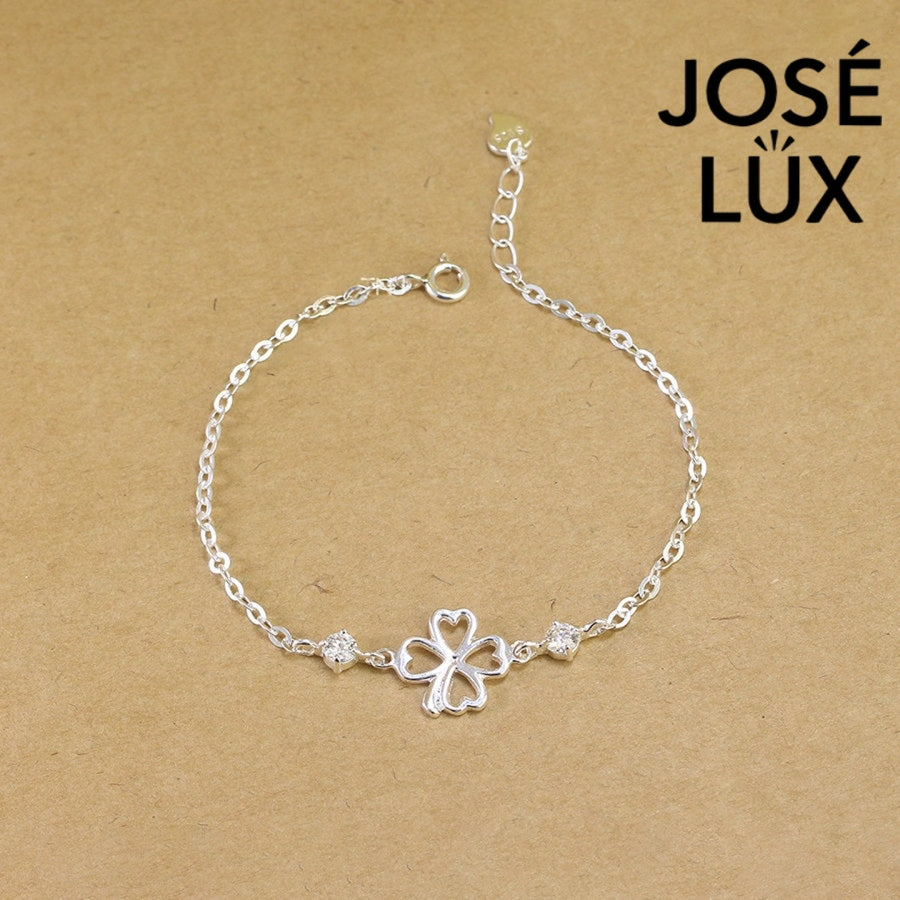 Open clover cable moissanite bracelet in sterling silver features minimalist four-leaf outline centerpiece with two brilliant stones totaling 0.6 carats on chain.