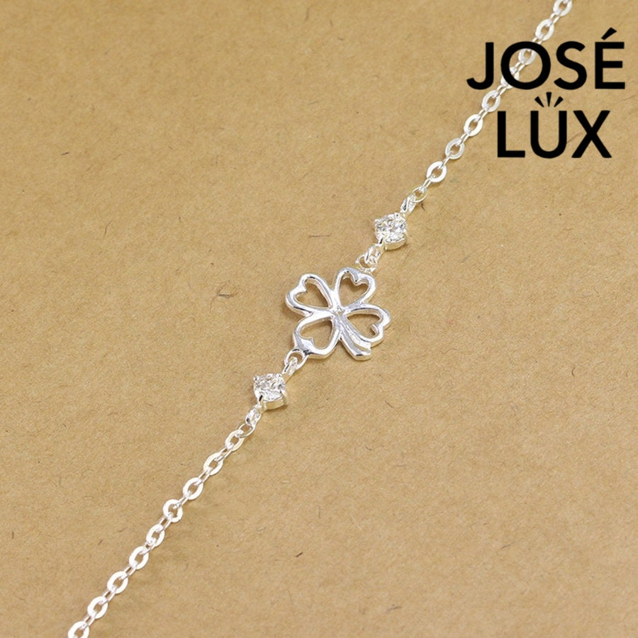 Open clover cable moissanite bracelet in sterling silver features minimalist four-leaf outline centerpiece with two brilliant stones totaling 0.6 carats on chain.