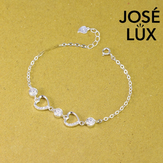 Pave heart station moissanite bracelet in sterling silver features two romantic heart motifs with three brilliant stones totaling 1.53 carats on cable chain.