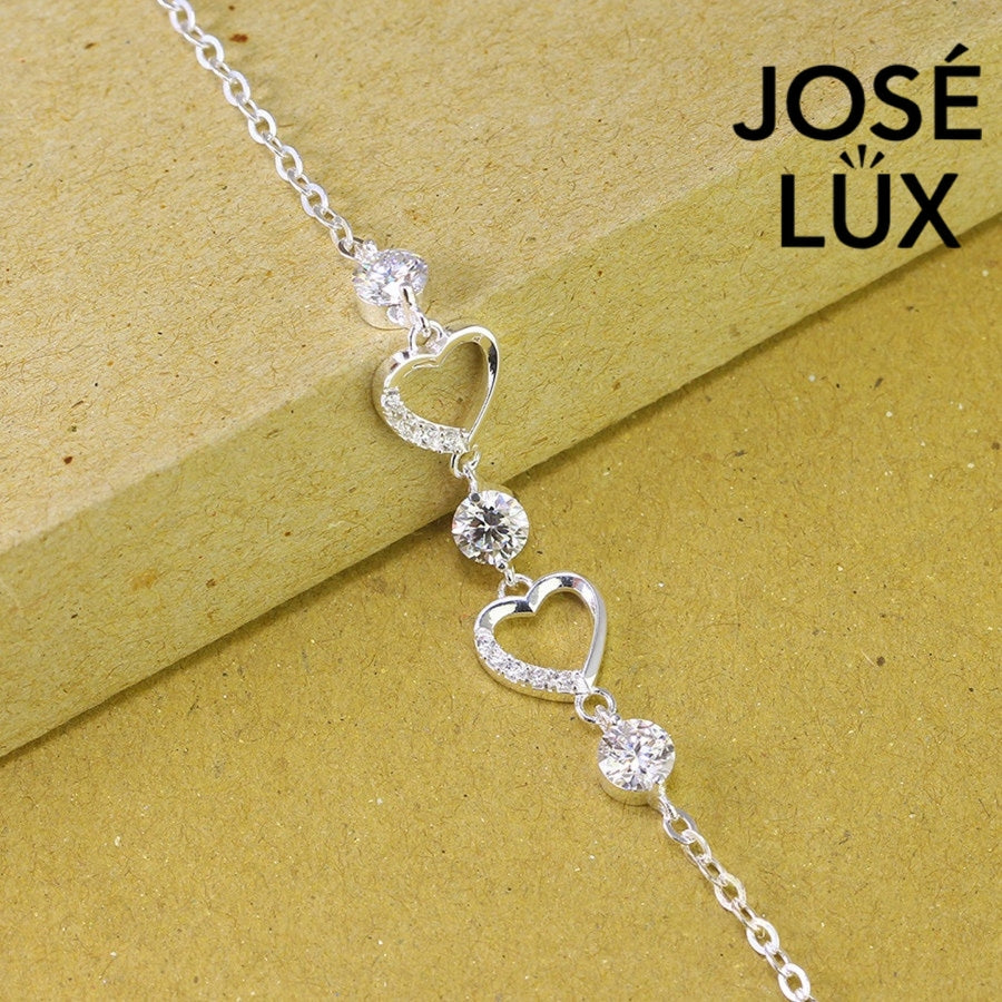 Pave heart station moissanite bracelet in sterling silver features two romantic heart motifs with three brilliant stones totaling 1.53 carats on cable chain.