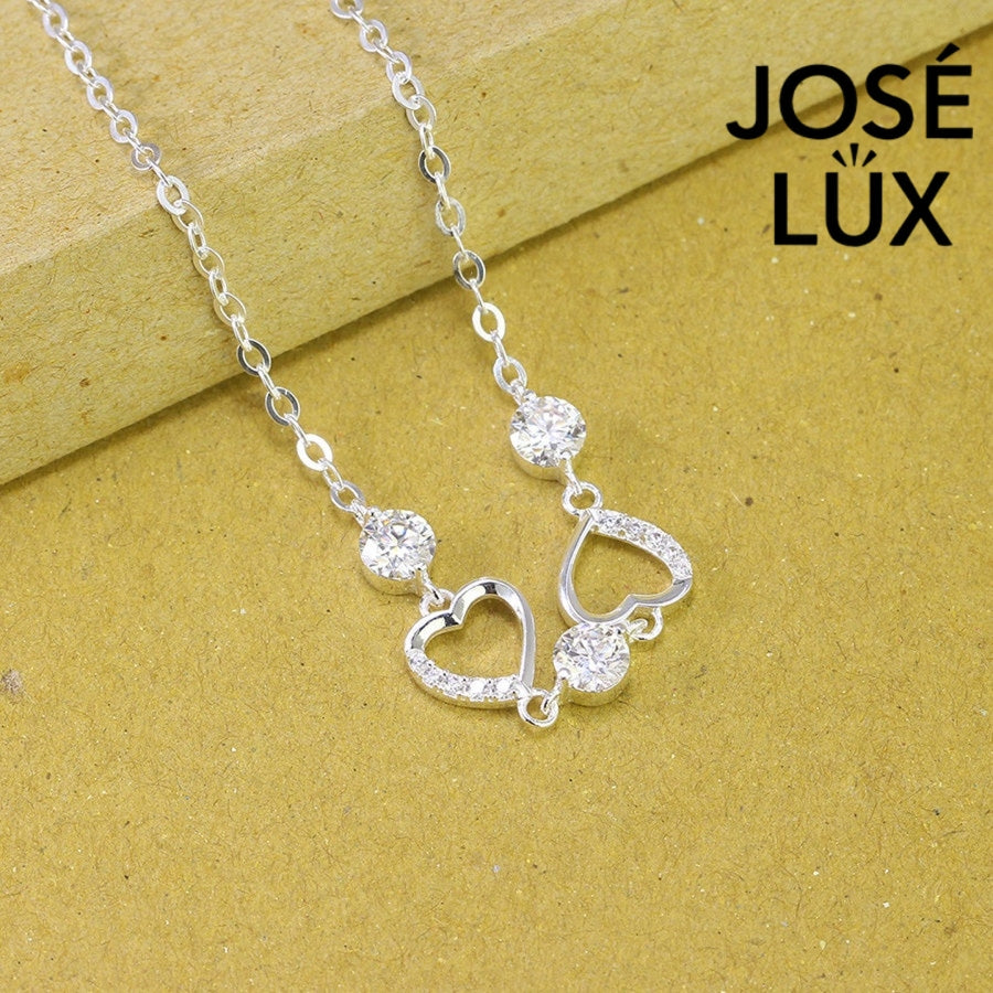 Pave heart station moissanite bracelet in sterling silver features two romantic heart motifs with three brilliant stones totaling 1.53 carats on cable chain.