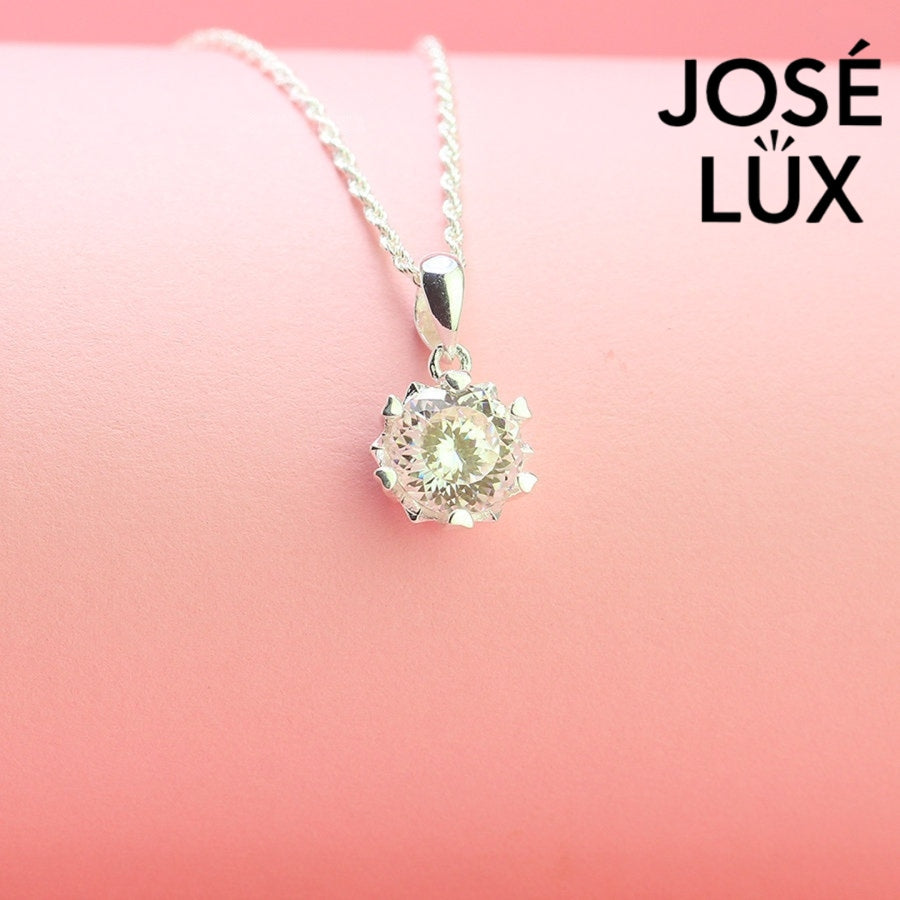 Brilliant round moissanite solitaire showcases exceptional fire and sparkle in an ornate crown setting, beautifully crafted in polished sterling silver.