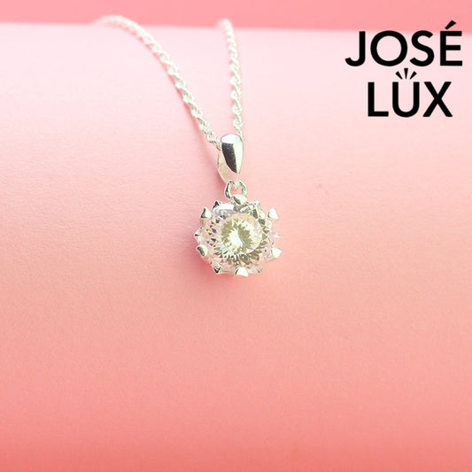 Brilliant round moissanite solitaire showcases exceptional fire and sparkle in an ornate crown setting, beautifully crafted in polished sterling silver.