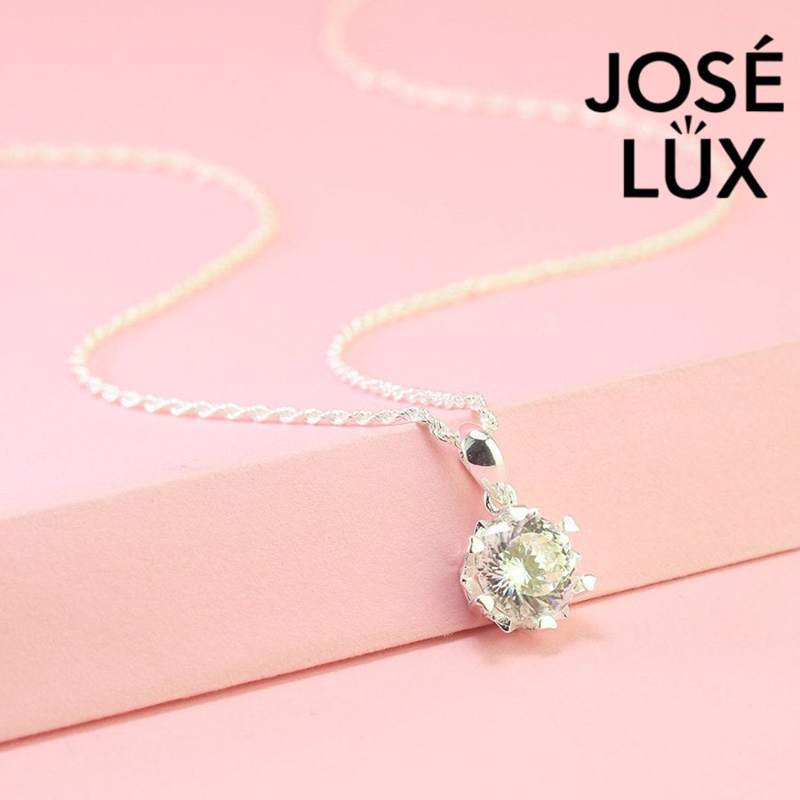 Brilliant round moissanite solitaire showcases exceptional fire and sparkle in an ornate crown setting, beautifully crafted in polished sterling silver.