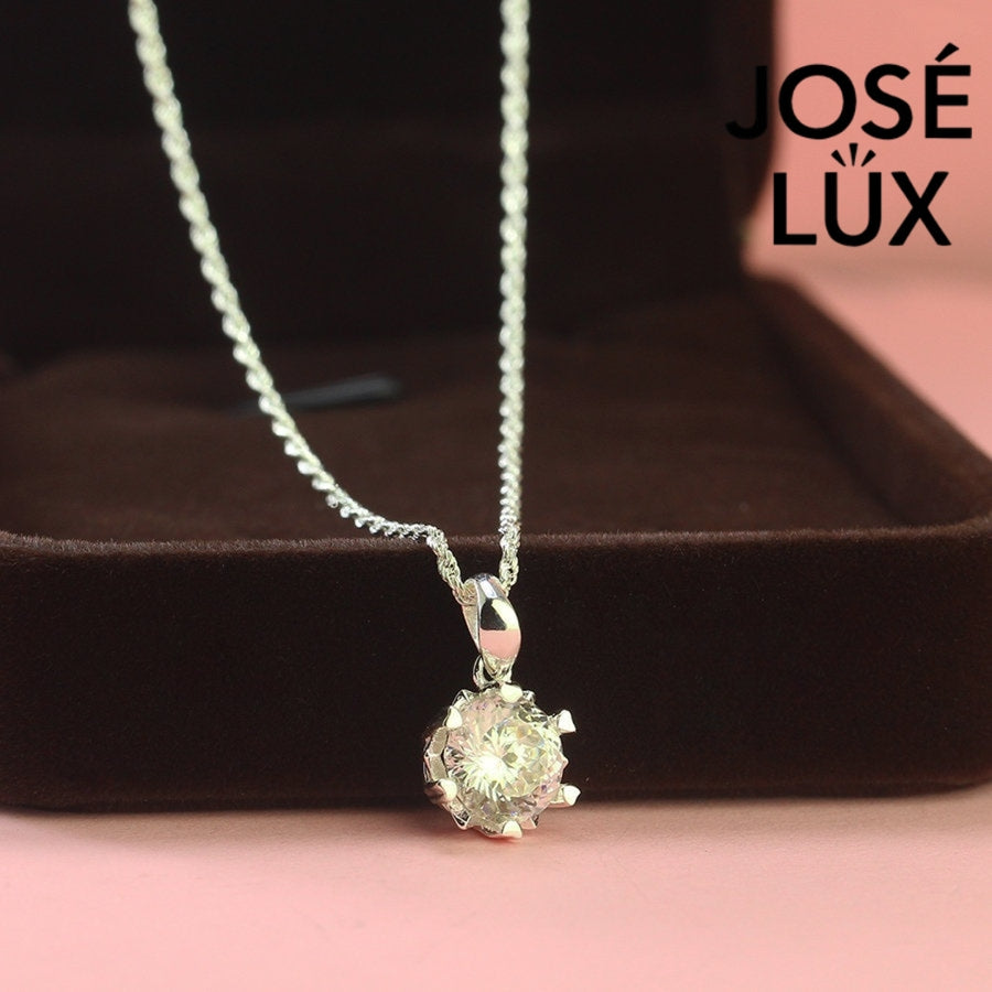 Brilliant round moissanite solitaire showcases exceptional fire and sparkle in an ornate crown setting, beautifully crafted in polished sterling silver.