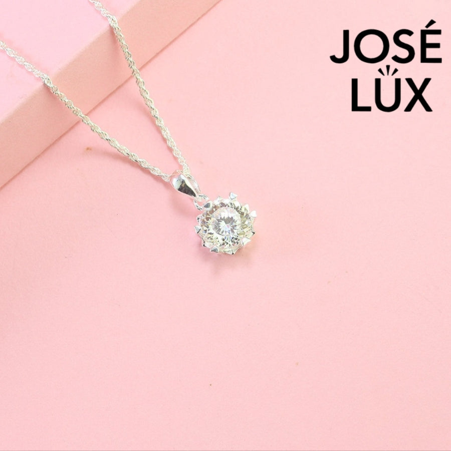 Brilliant round moissanite solitaire showcases exceptional fire and sparkle in an ornate crown setting, beautifully crafted in polished sterling silver.