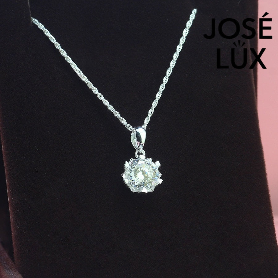 Brilliant round moissanite solitaire showcases exceptional fire and sparkle in an ornate crown setting, beautifully crafted in polished sterling silver.