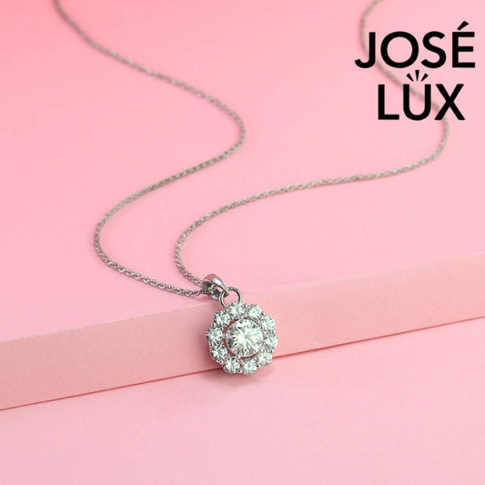 Timeless round moissanite pendant surrounded by scalloped halo design creates vintage-inspired elegance, expertly handcrafted in lustrous sterling silver for lasting beauty.