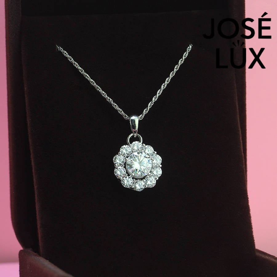 Timeless round moissanite pendant surrounded by scalloped halo design creates vintage-inspired elegance, expertly handcrafted in lustrous sterling silver for lasting beauty.