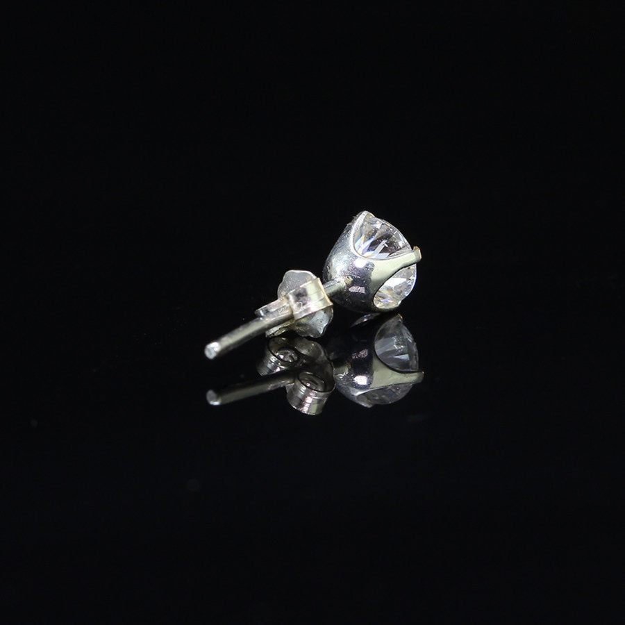 Sterling silver 0.5ct Round Moissanite Stud Earring for Men shown lying flat, highlighting 4-prong setting and post design.