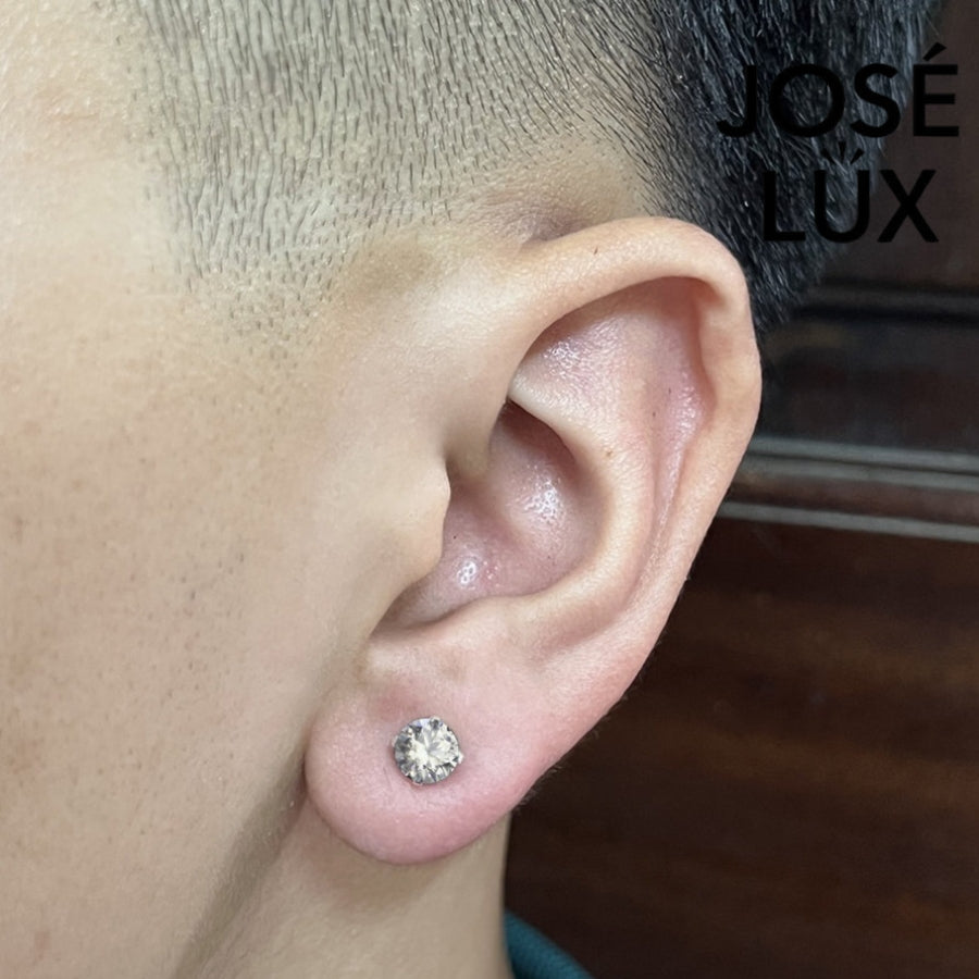 Sterling silver 0.8ct round moissanite stud earring worn by man, showcasing elegant 4-prong setting and everyday fit.