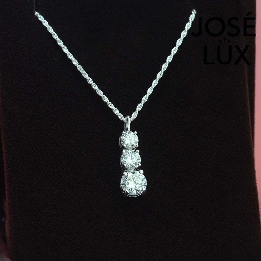 Elegant three-stone graduated moissanite pendant features brilliant round stones in classic drop design, crafted in durable sterling silver for everyday elegance.